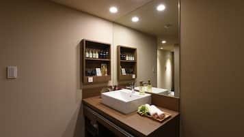 A modern bathroom with a large mirror, two sinks, wooden shelves with toiletries, and a towel rack.