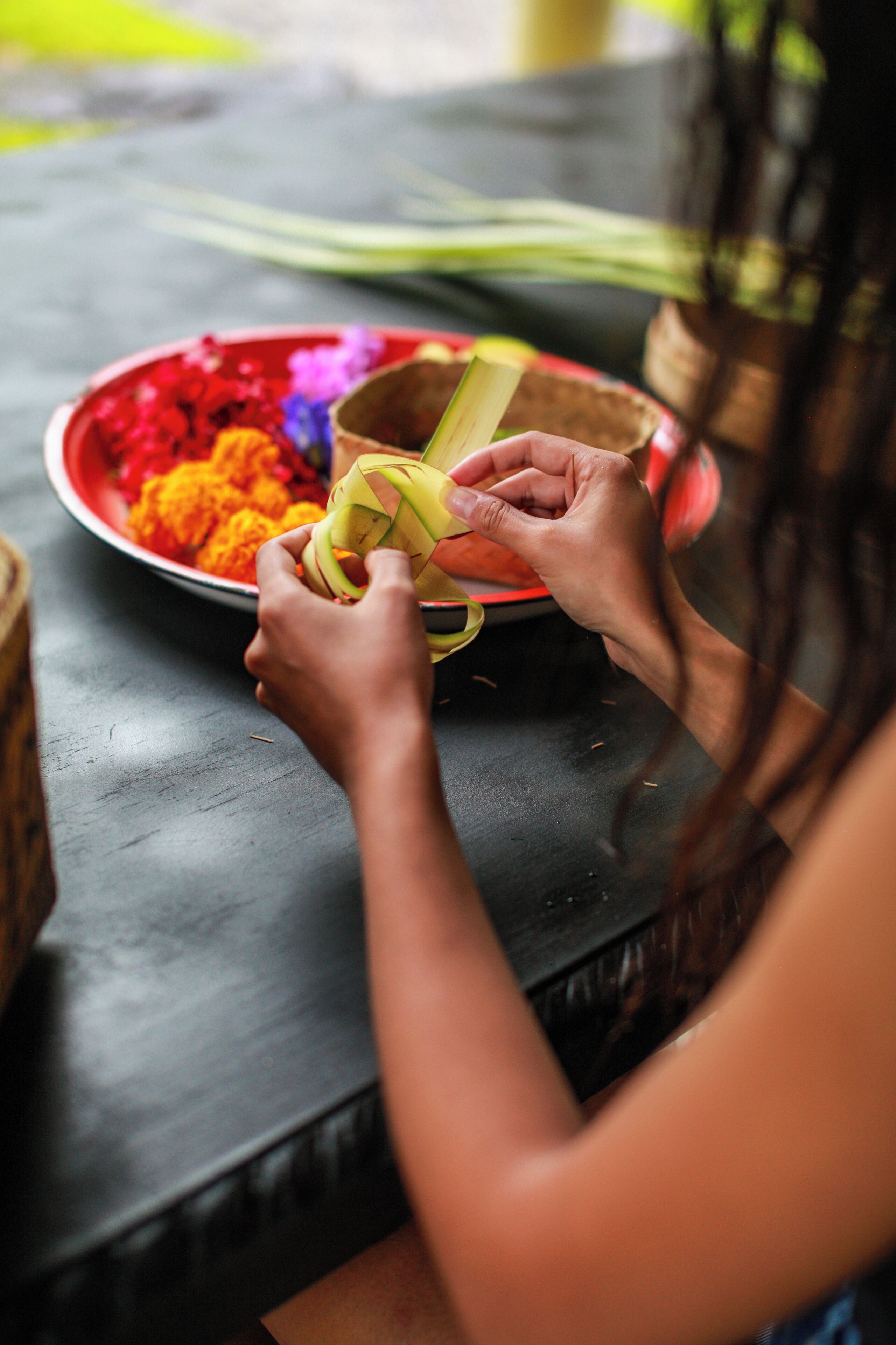A person preparing a dish with a plate of colorful ingredients and a bowl.