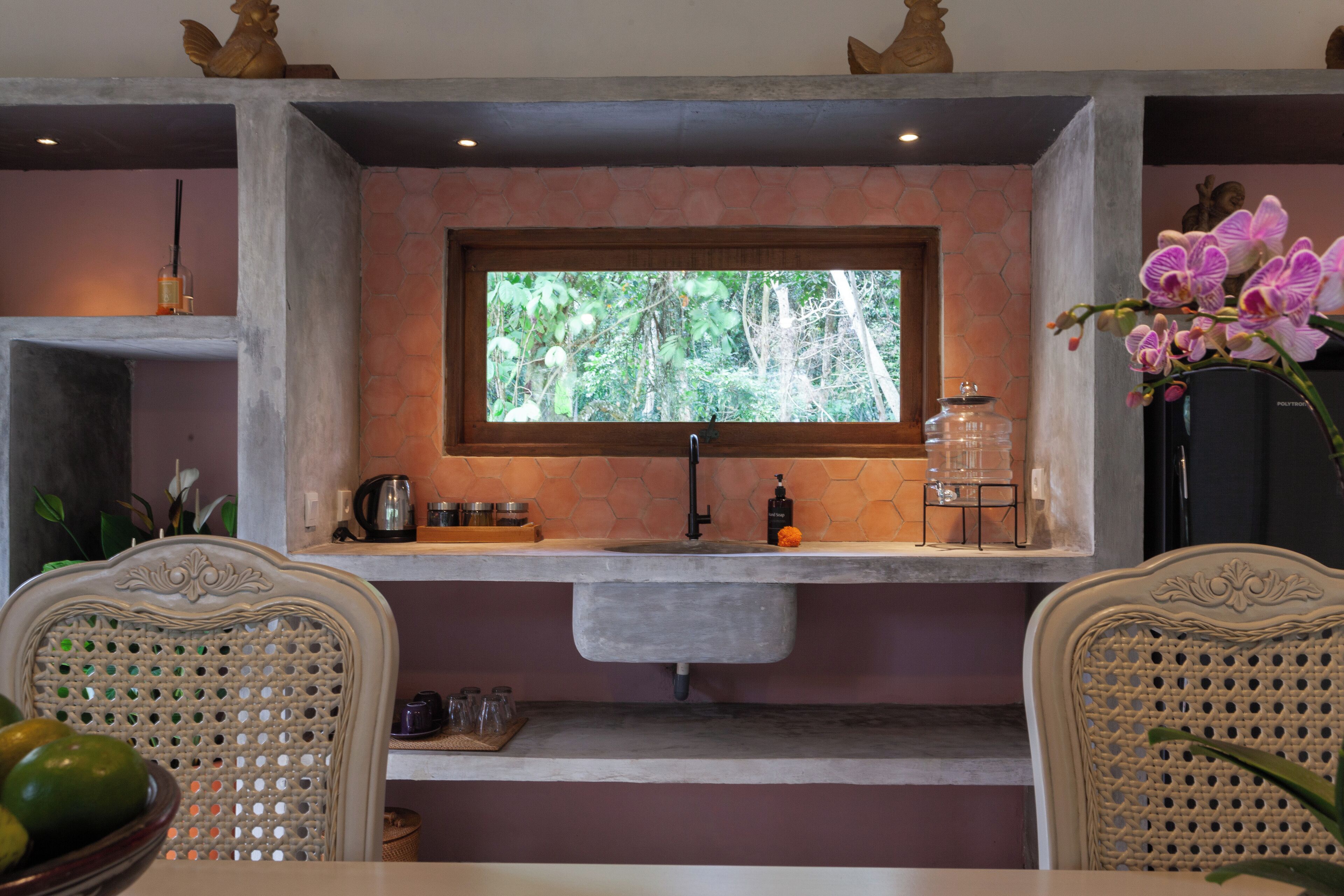 A kitchen with a window, a sink, and a countertop with various items.