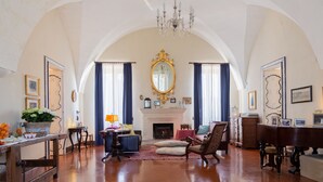 A spacious living room with a fireplace, elegant furniture, and a large mirror. - Villa Spada Donadeo (Lequile)