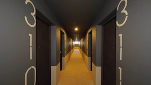 Un pasillo de hotel con puertas numeradas 301, 302 y 303.