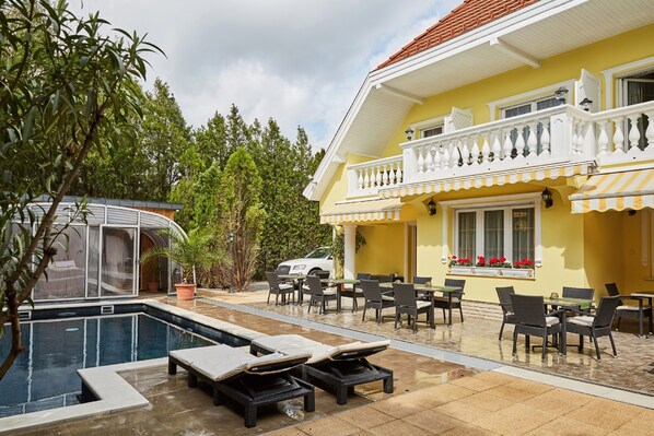 Relax by the pool surrounded by lush greenery and comfortable lounge chairs.