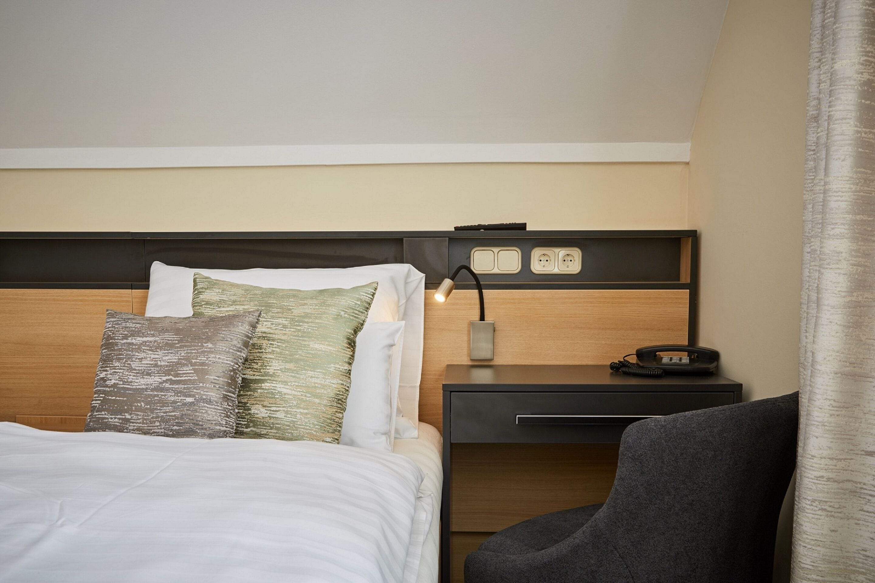 Una habitación de hotel con una cama, un escritorio y una silla.