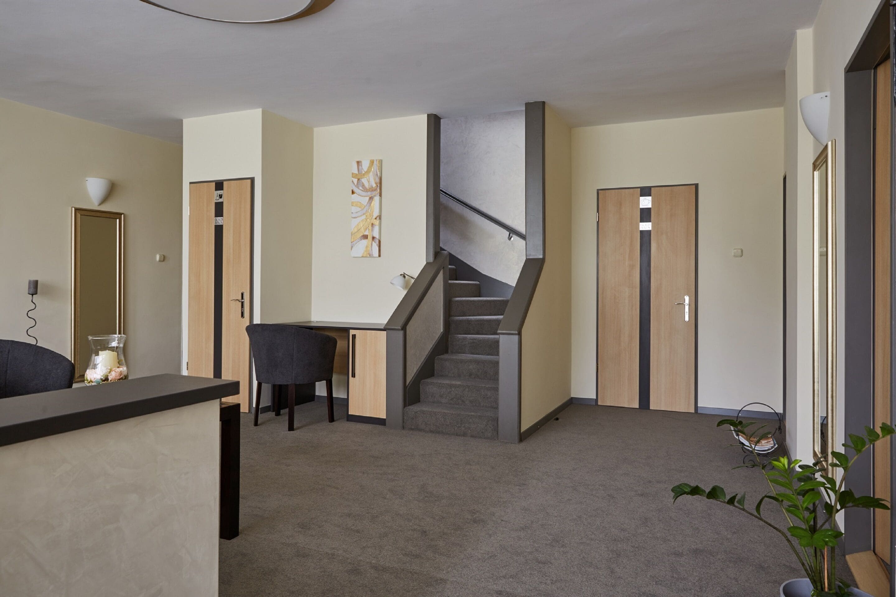 Un interior moderno con mostrador de recepción, una escalera y una zona de estar.