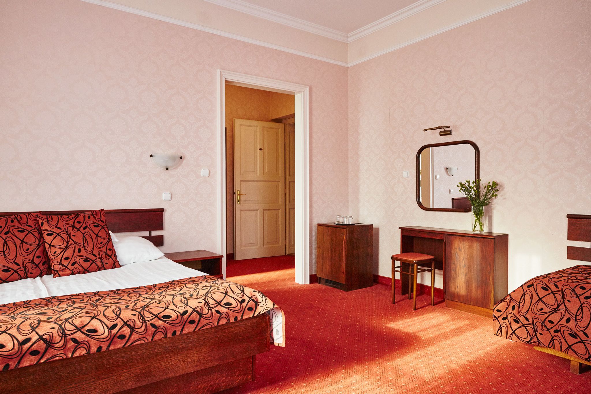 Una habitación de hotel con una cama, un escritorio, una silla y un armario.