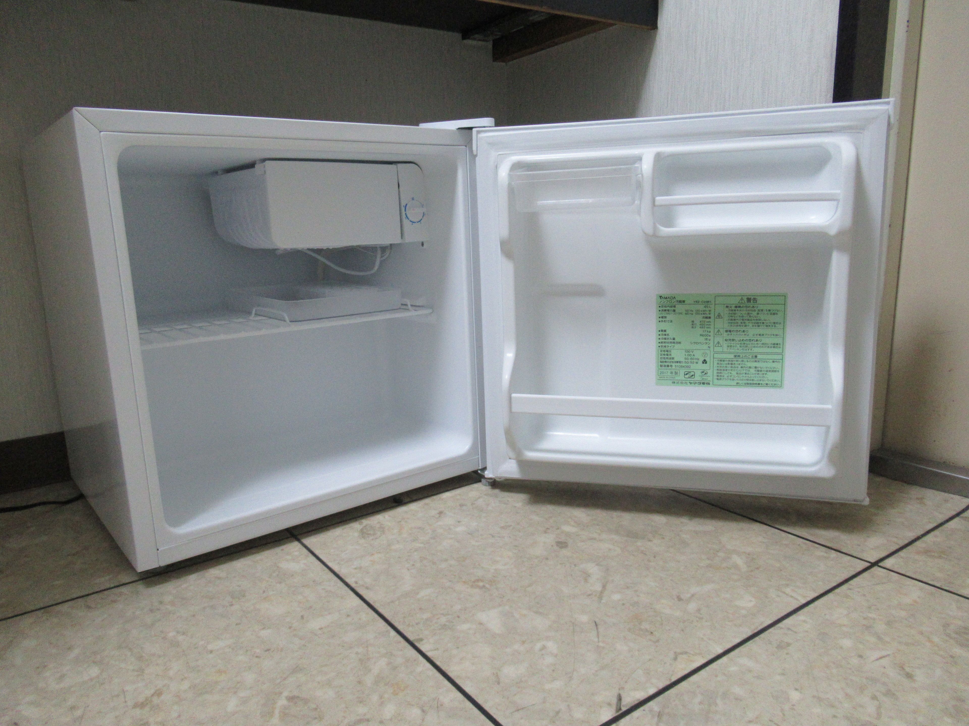 Un refrigerador abierto con un panel de control y una etiqueta en la puerta.