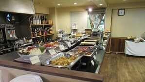 Un bufé con diversas opciones de comida y una selección de bebidas.
