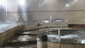 Un baño de vapor con varias jacuzzis y una fuente central.