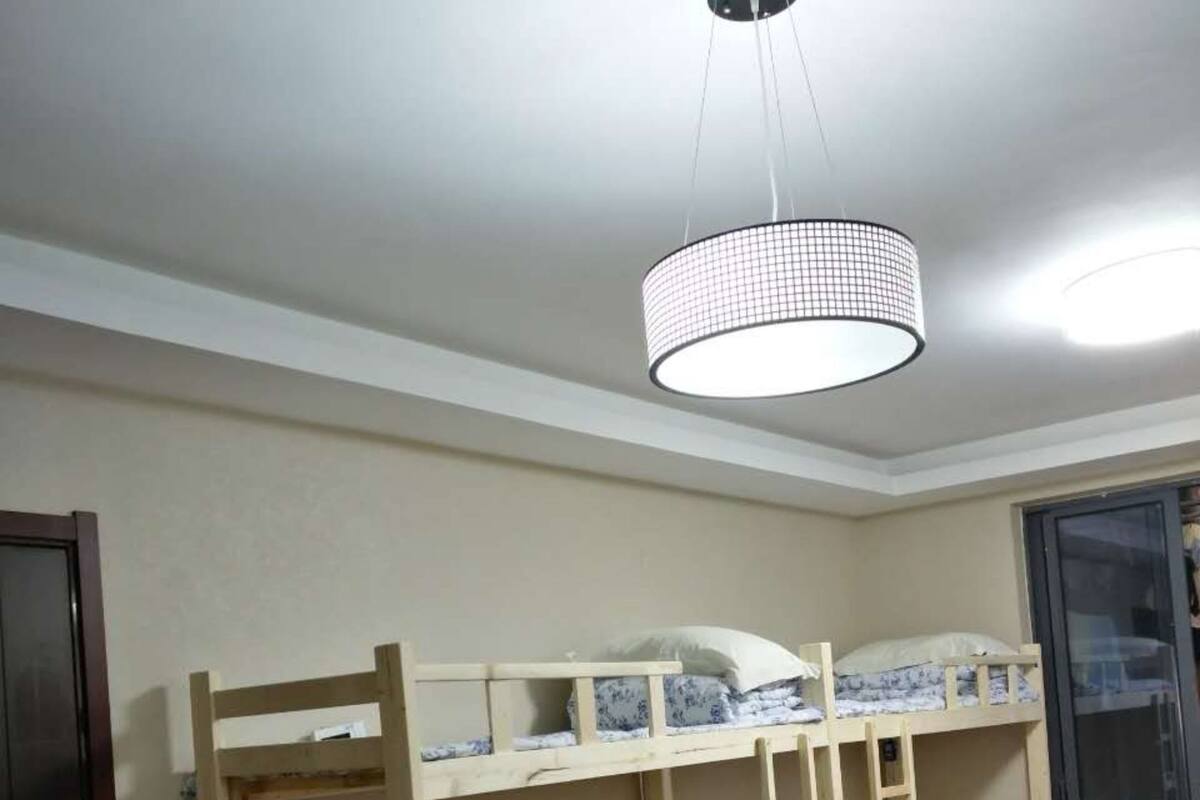 A bunk bed room with a ceiling light fixture and a sliding glass door.
