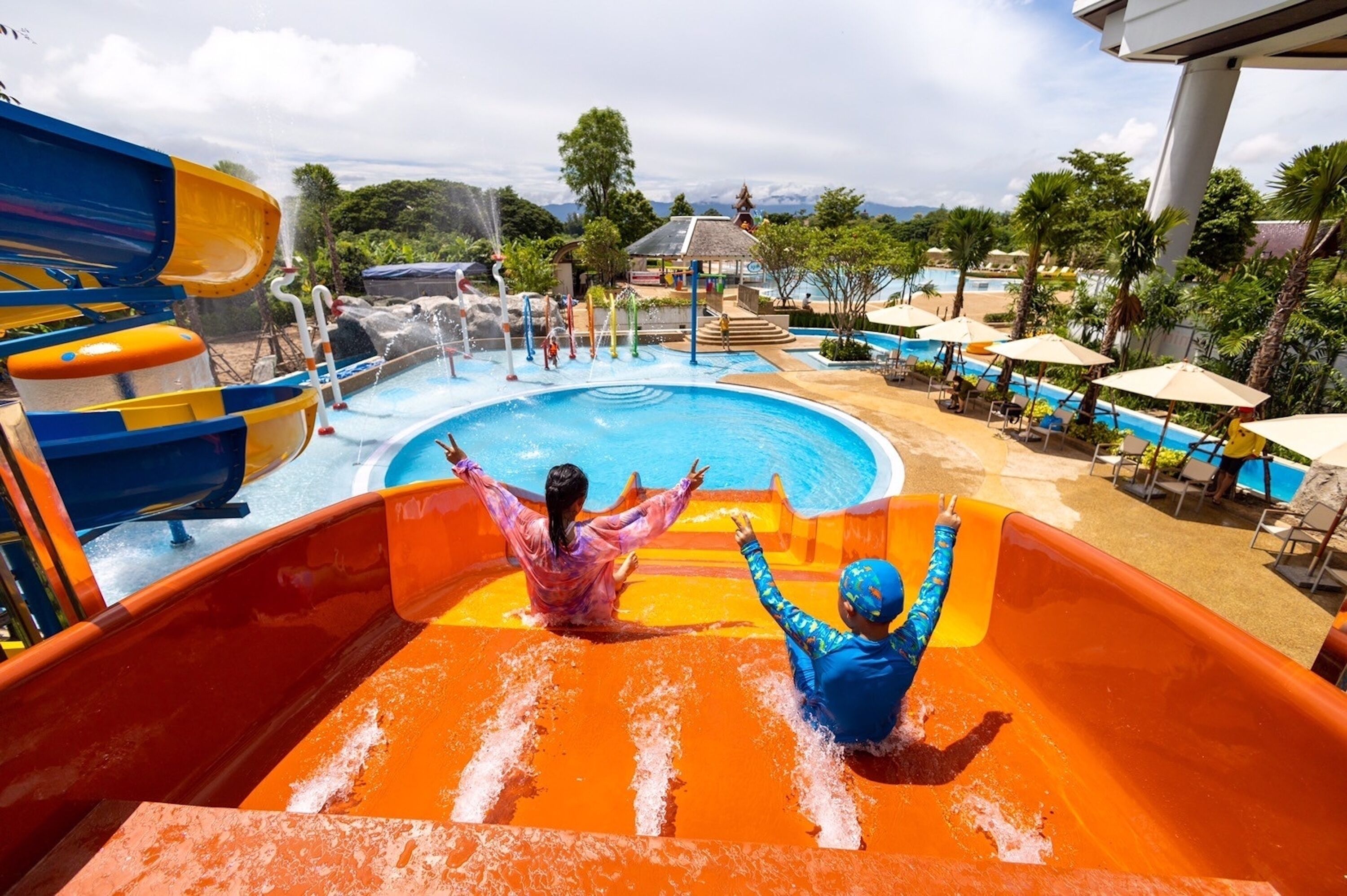 Ein Wasserpark mit großem Pool, Rutschen und Liegebereichen.