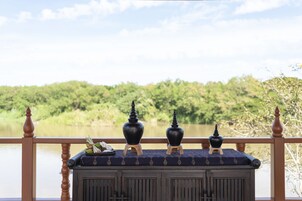 A balcony with a view of a lake and forest.
