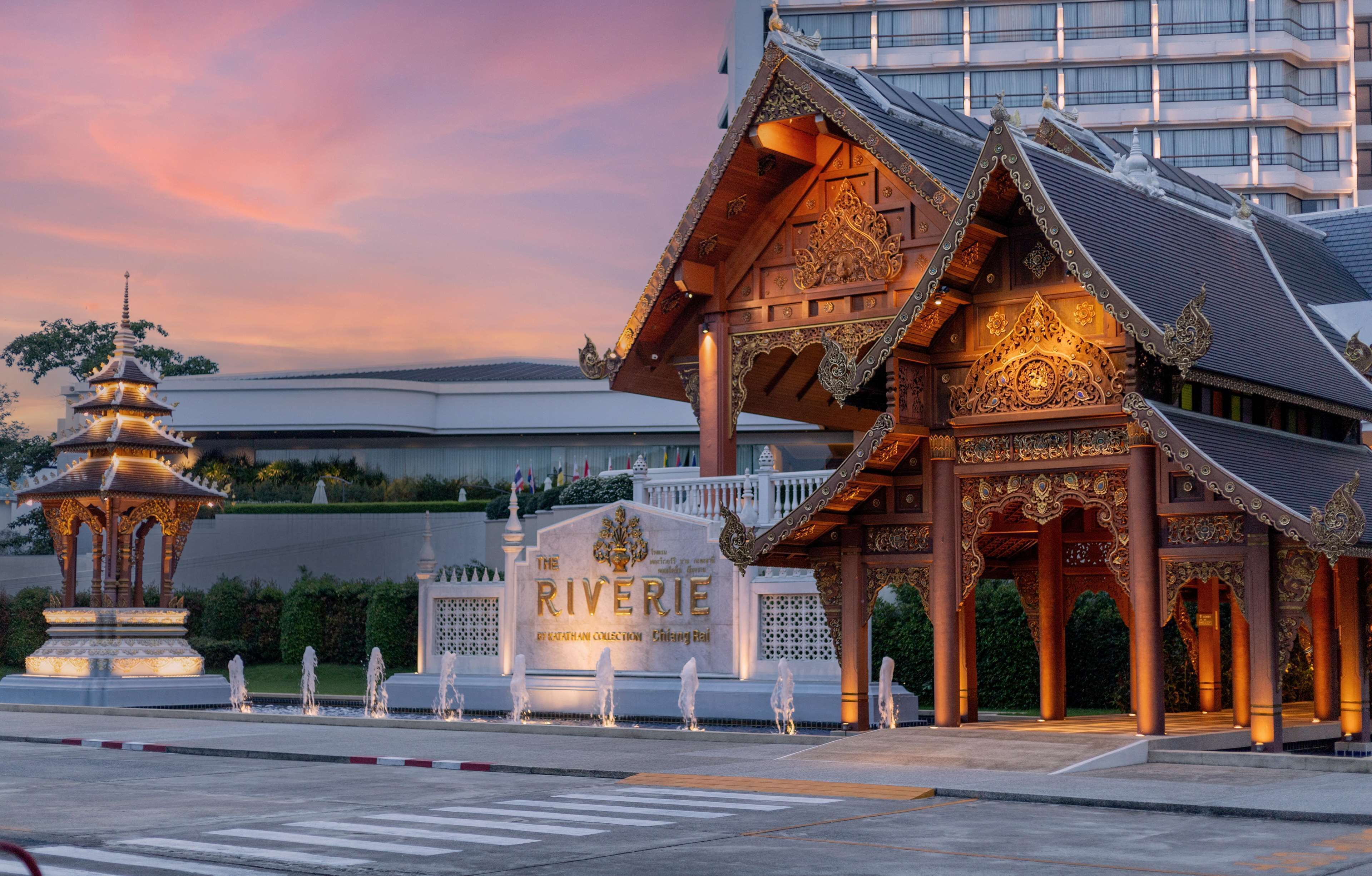 A traditional Thai building with ornate architecture, a pagoda, and a sign reading "The Riverie."