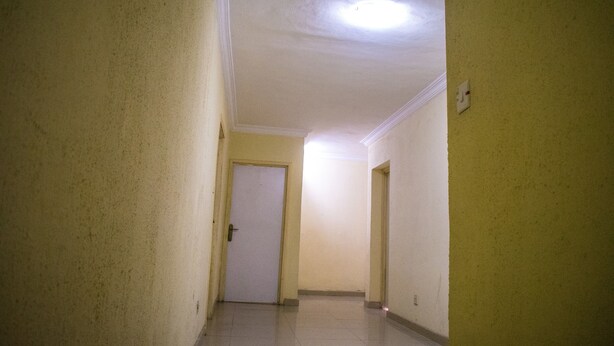 A narrow hallway with a white door at the end, plain walls, and a ceiling light. - Ikeja Transit Hotel (Lagos)