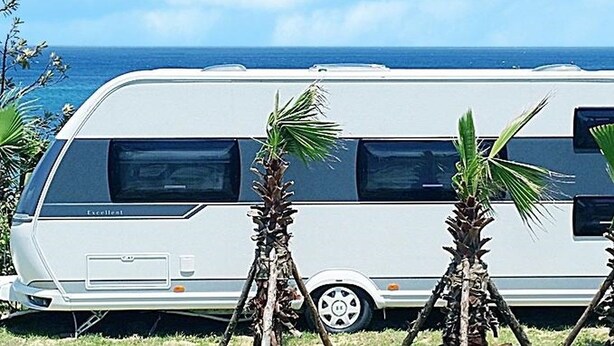 A white RV parked on a grassy area with a view of the ocean. - Jeju Platinum Caravan (Jeju City)