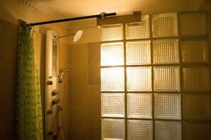 Deluxe-studiolejlighed | Badeværelse | Bruser, brusehoved med hydromassage, gratis toiletartikler, håndklæder