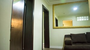 A hallway with a large mirror, a dark-colored sofa, and a door.