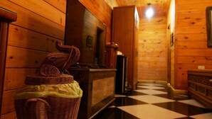 Un interior de madera con piso a cuadros, una cesta de mimbre y un banco de madera.