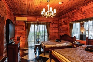 A wooden cabin room with two beds, a TV, and a chandelier. - Sun Moon Lake Full House Resort (Yuchi)