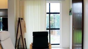 A modern living room with a white sofa, a black armchair, and a wooden floor. - Void (Jeju City)