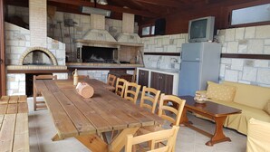 Una cocina rústica con pared de piedra, mesa y sillas de madera.