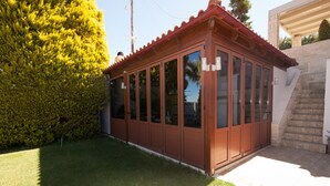 Un pequeño edificio de una sola planta con techo rojo y ventanas amplias.