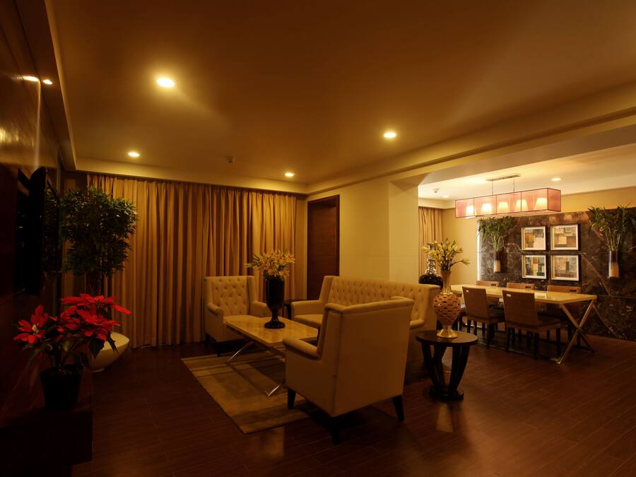 A modern living room with a sofa, armchairs, a coffee table, and a dining table.