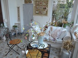 Un salón acogedor con suelo estampado, un sofá, una mesa de centro y una rama decorativa con adornos.
