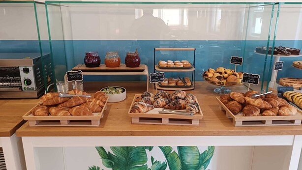A bakery display with various pastries and baked goods, including croissants and muffins, with labels in a foreign language. - Hotel Berenice Rimini Mare (Rimini)