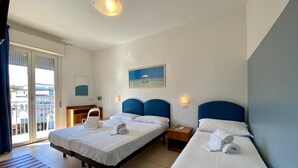 A hotel room with two beds, a desk, a chair, a nightstand, and a view of the sea through a balcony. - Hotel Berenice Rimini Mare (Rimini)