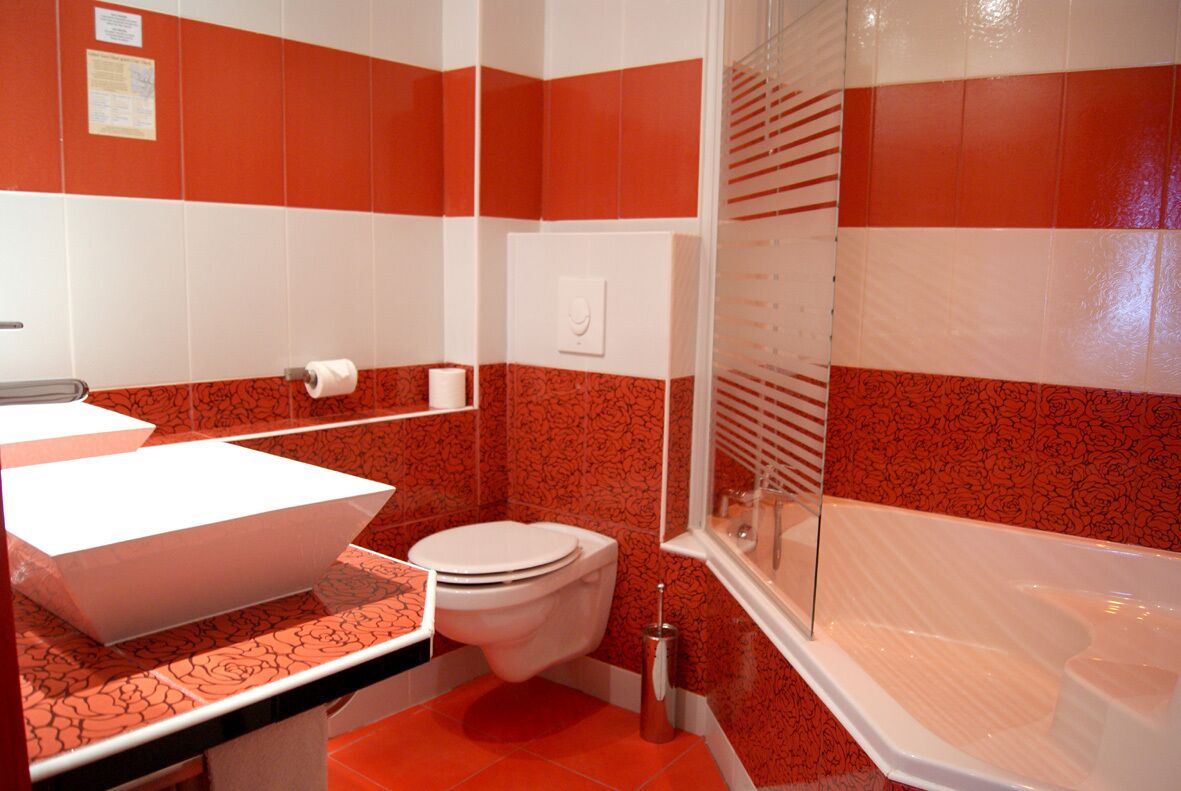 Un baño con lavamanos blanco, inodoro blanco y bañera.