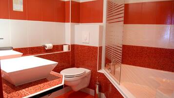 Un baño con lavamanos blanco, inodoro blanco y bañera.
