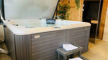 A hot tub with a glass top, a small step stool, and a towel on the step.