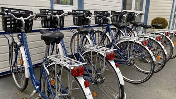 Varias bicicletas estacionadas frente a un edificio de fachada azul y blanca.
