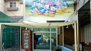 A hotel entrance with a cartoon mural above the door.