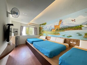 A hotel room with two beds, a mural of a forest scene, a fan, and a desk with a computer. - Baisha B&B (Liuqiu)