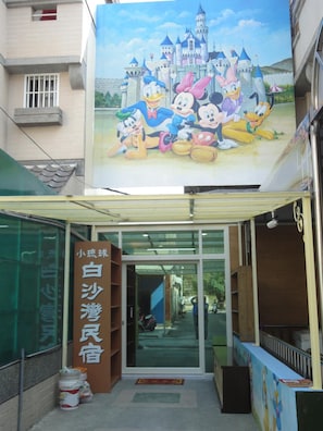 A storefront with a large Disney-themed mural above the entrance. - Baisha B&B (Liuqiu)