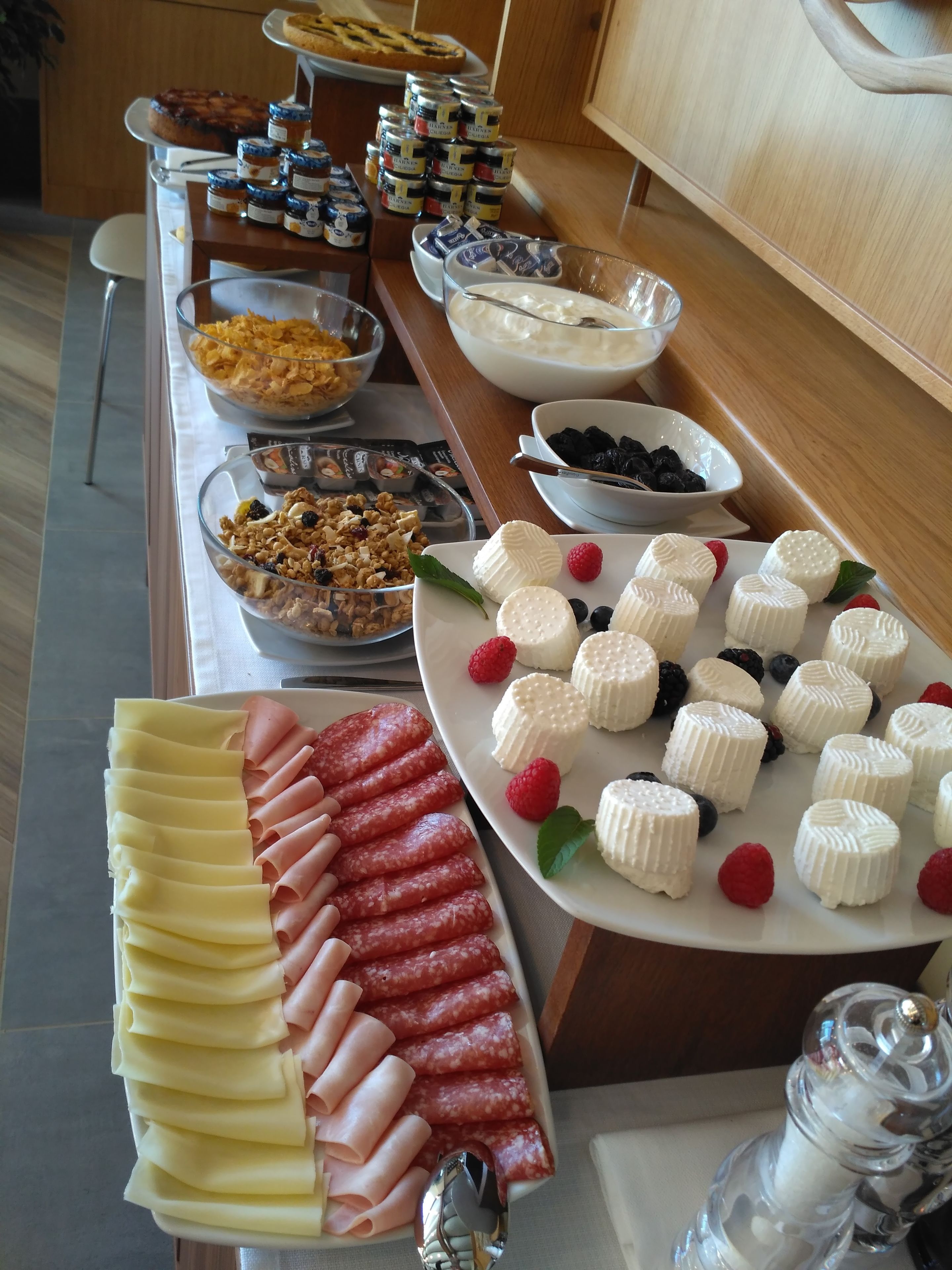 Ein reichhaltiges Buffet mit verschiedenen Speisen, darunter Käse, Wurstwaren und Obst.