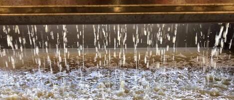 A close-up of a water feature with multiple streams of water flowing into a pool.