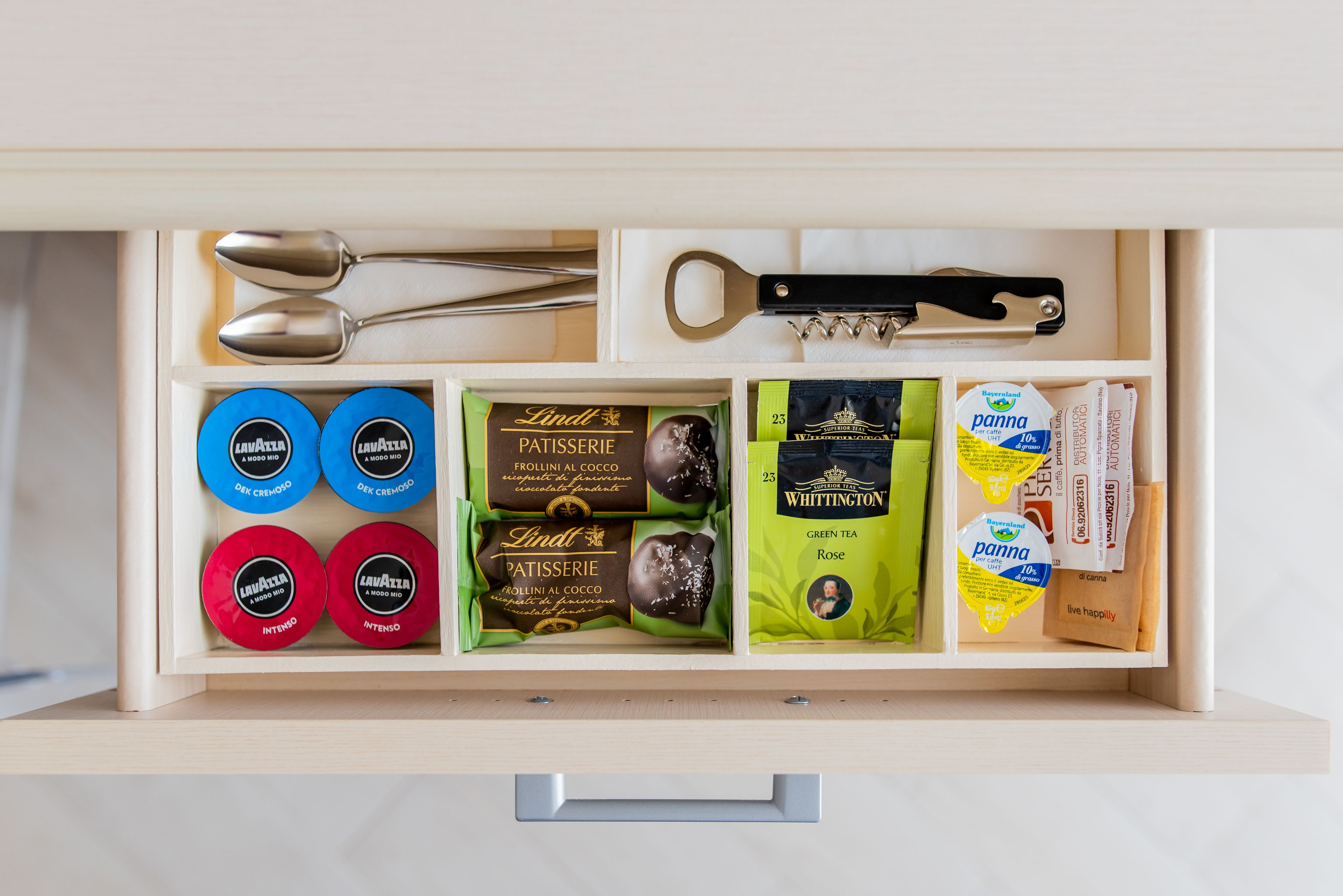 Un cajón con diversos productos alimenticios, como bombones, té y aperitivos.
