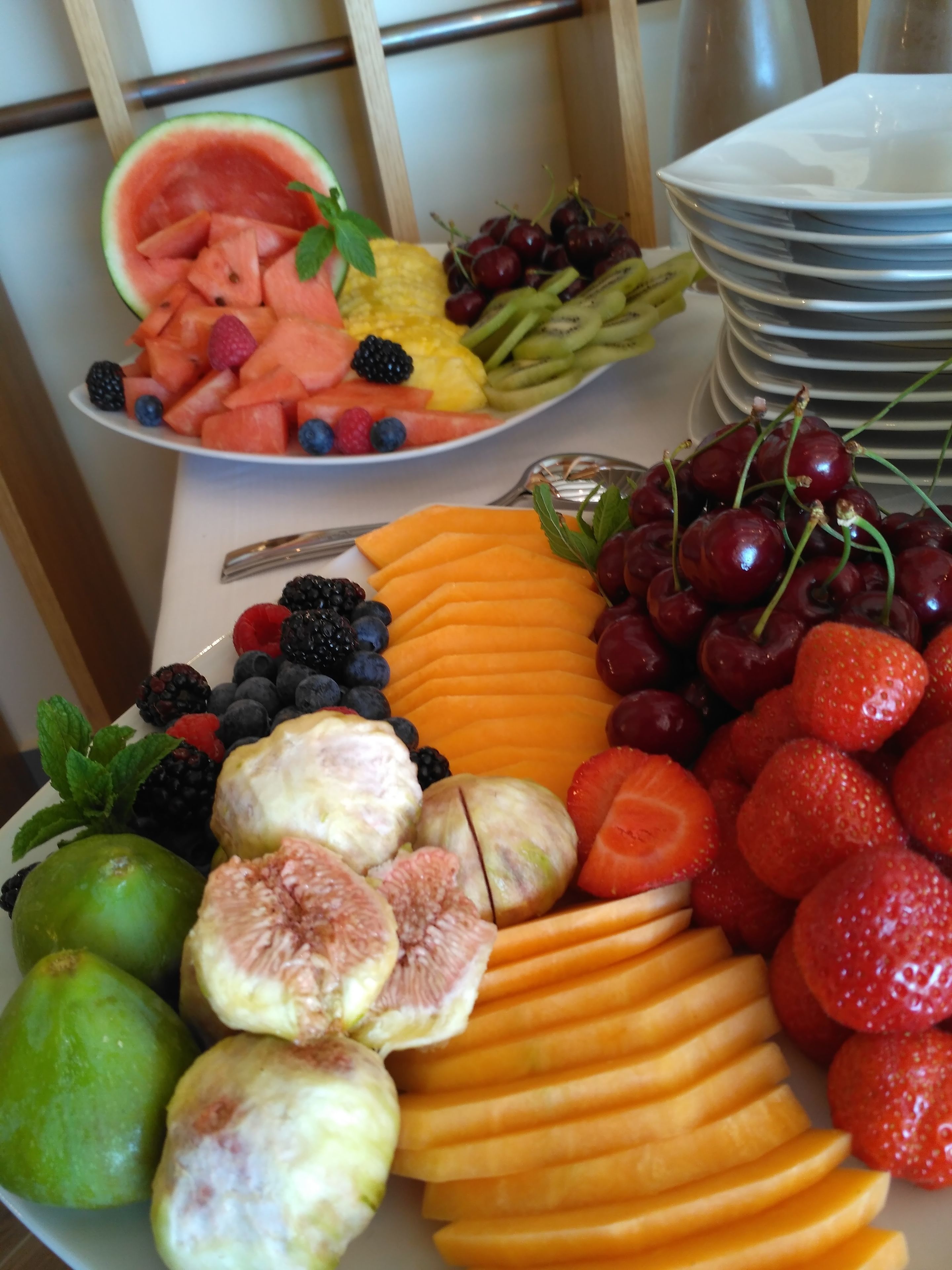A fruit platter with watermelon, cherries, strawberries, and other fruits.