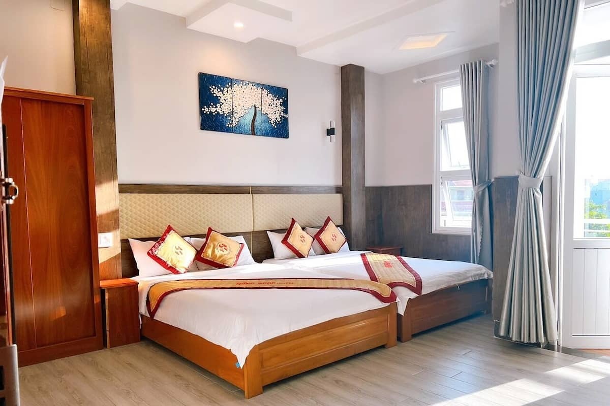 Une chambre d’hôtel avec un grand lit, une tête de lit en bois et une vue sur l’extérieur.