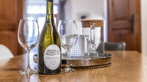 A bottle of prosecco wine, two wine glasses, and a metal tray on a wooden table. - Apartman Baron (Cesky Krumlov)
