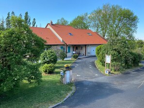 A two-story building with a red-tiled roof, a covered porch, and a driveway leading to a gated entrance. - Chambre D'hôtes LA Colombe (Xouaxange)