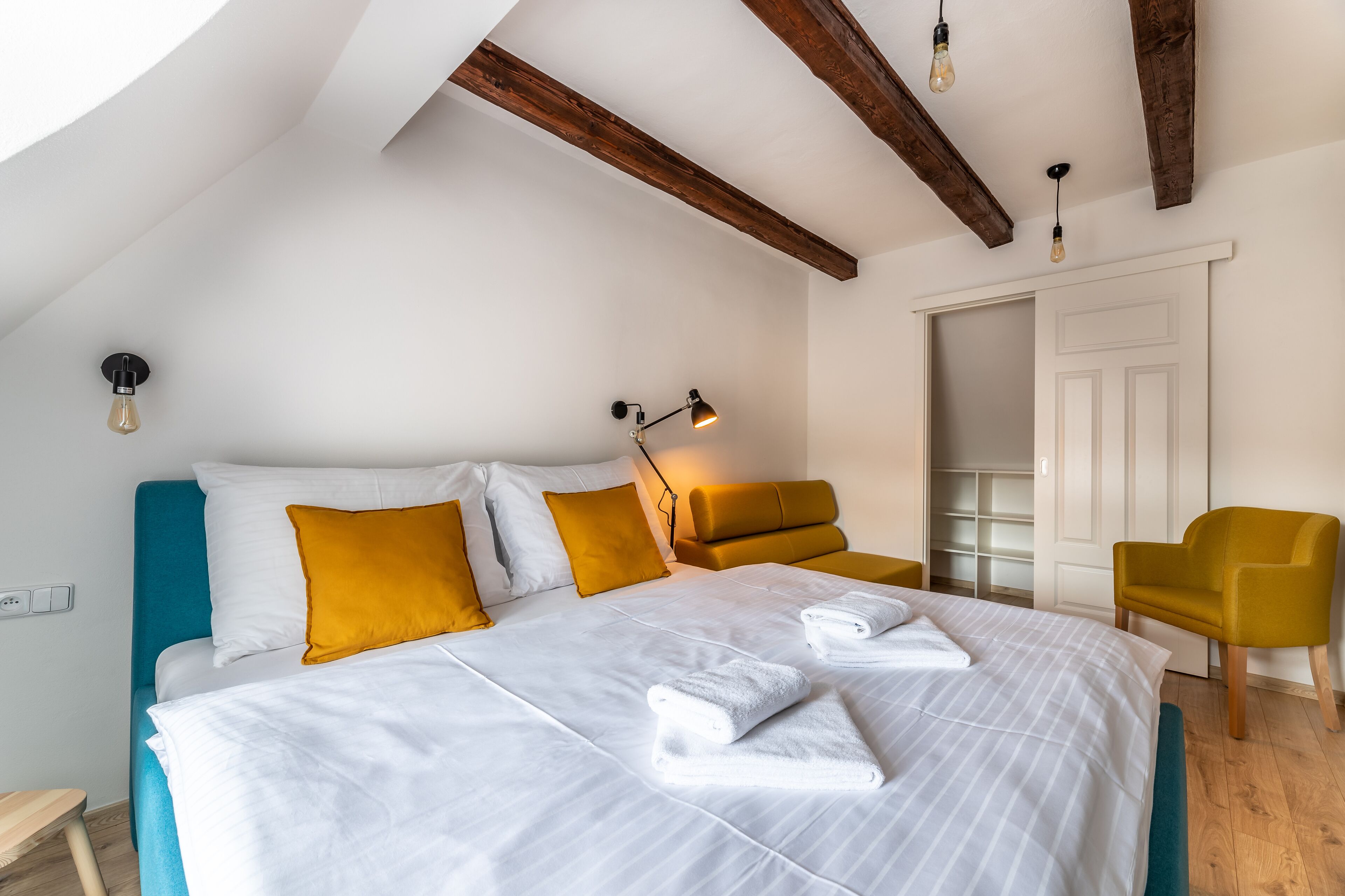 Une chambre à coucher avec un grand lit, deux tables de chevet, une chaise et une armoire.