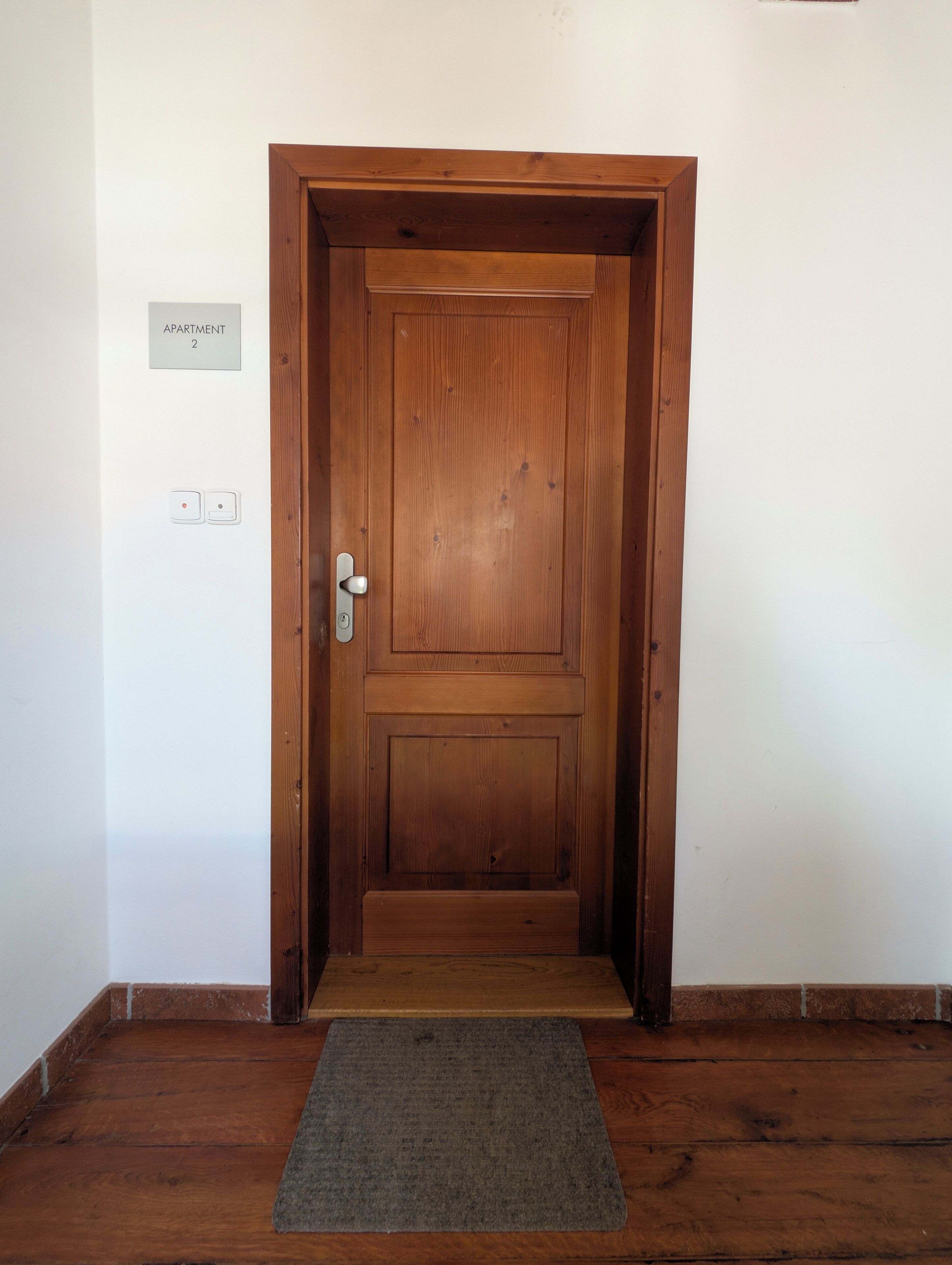 Una puerta de madera con un cartel arriba que dice 'APARTMENT 2'.