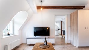 Una sala de estar moderna con una mesa de madera, un televisor de pantalla plana y una botella de vino.