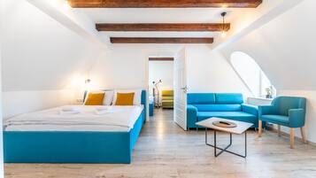 Un dormitorio estilo loft moderno con una cama grande, un sofá azul y una mesita.