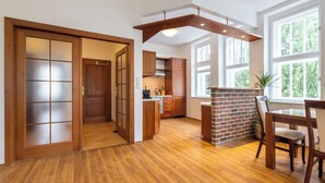 Una cocina amplia con armarios de madera, una pared de acento de ladrillo y un comedor con mesa y sillas.