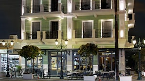 Un immeuble à plusieurs étages doté d’une façade verdoyante, de nombreux balcons et d’espaces extérieurs aménagés pour s’asseoir.