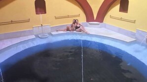 Une piscine aux couleurs jaune et bleu, entourée d’arcs rouges et surmontée d’un plafond jaune.